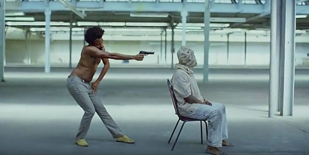 Childish Gambino shoots a guitar player in the video for "This is America"